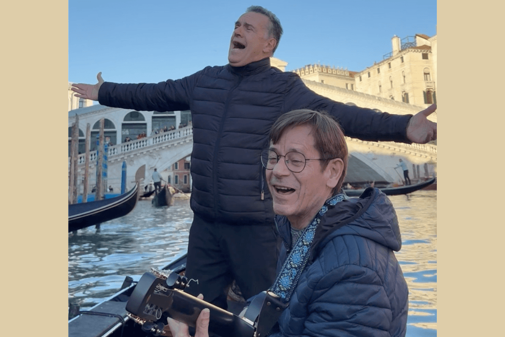 Two men singing and playing music on a gondola in Venice, Italy.