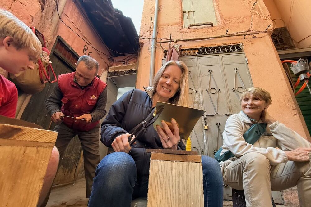 Brook Wilkinson and family visiting a brass workshop in the Medina of Marrakech, Morocco.