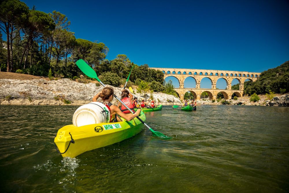 People kayaking under the bridge Pont du Gard in France.