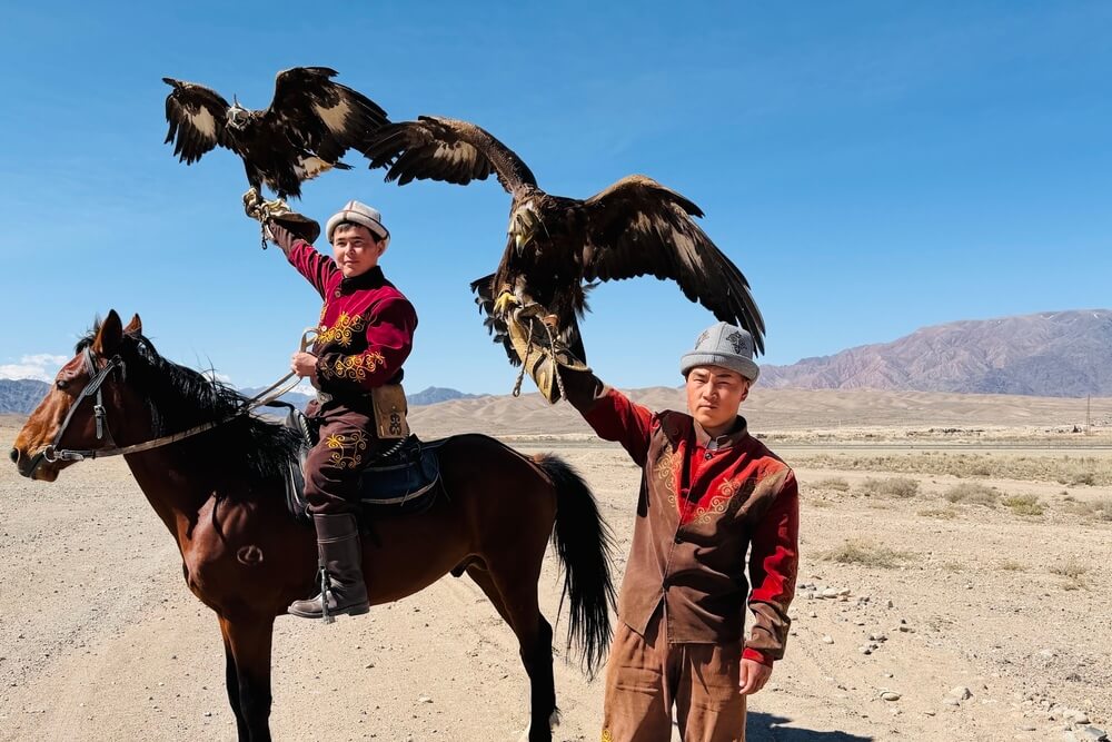 Two locals holding eagles in Kyrgyzstan.