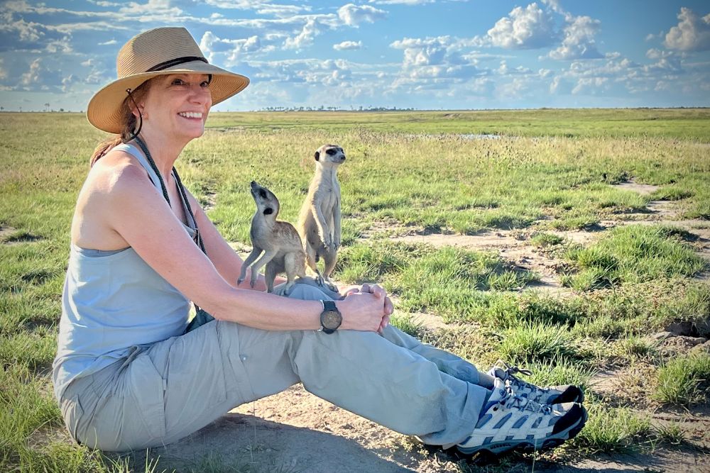 Nichole Bernier posing with meerkats in Botswana.