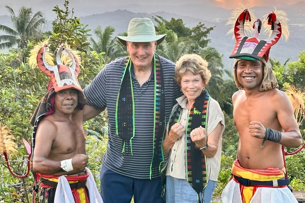 Christine Stoll and her husband with traditional whip dancers in Manggarai village, Indonesia.