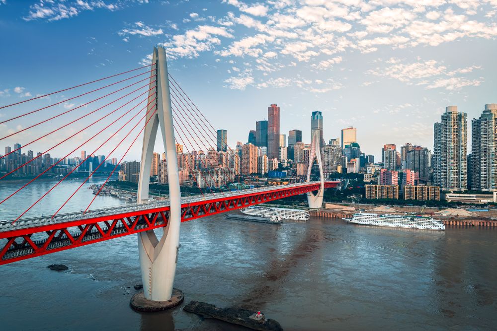 Modern cable-stayed bridge spanning the river with the urban cityscape in Chongqing, China.